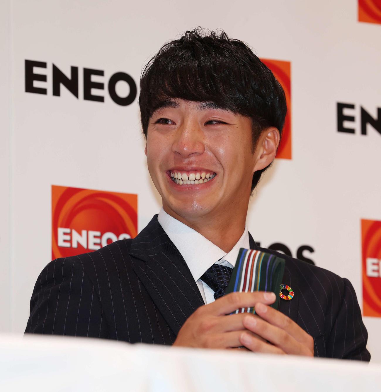 DeNAから1位指名を受け、涙をENEOS・大久保監督から借りたハンカチで拭き笑顔を見せる度会（撮影・宮地輝）