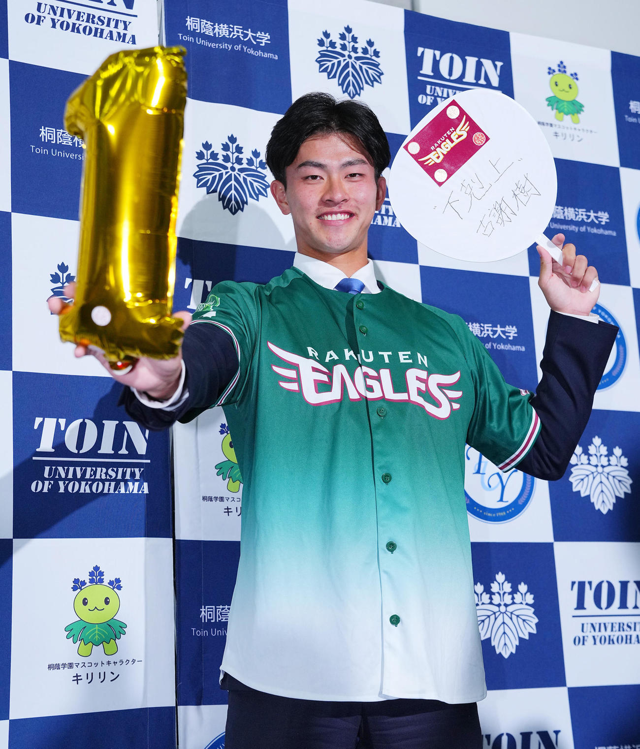 楽天から1位指名を受けた桐蔭横浜大・古謝は「下剋上」の言葉を記し笑顔で写真に納まる（撮影・垰建太）