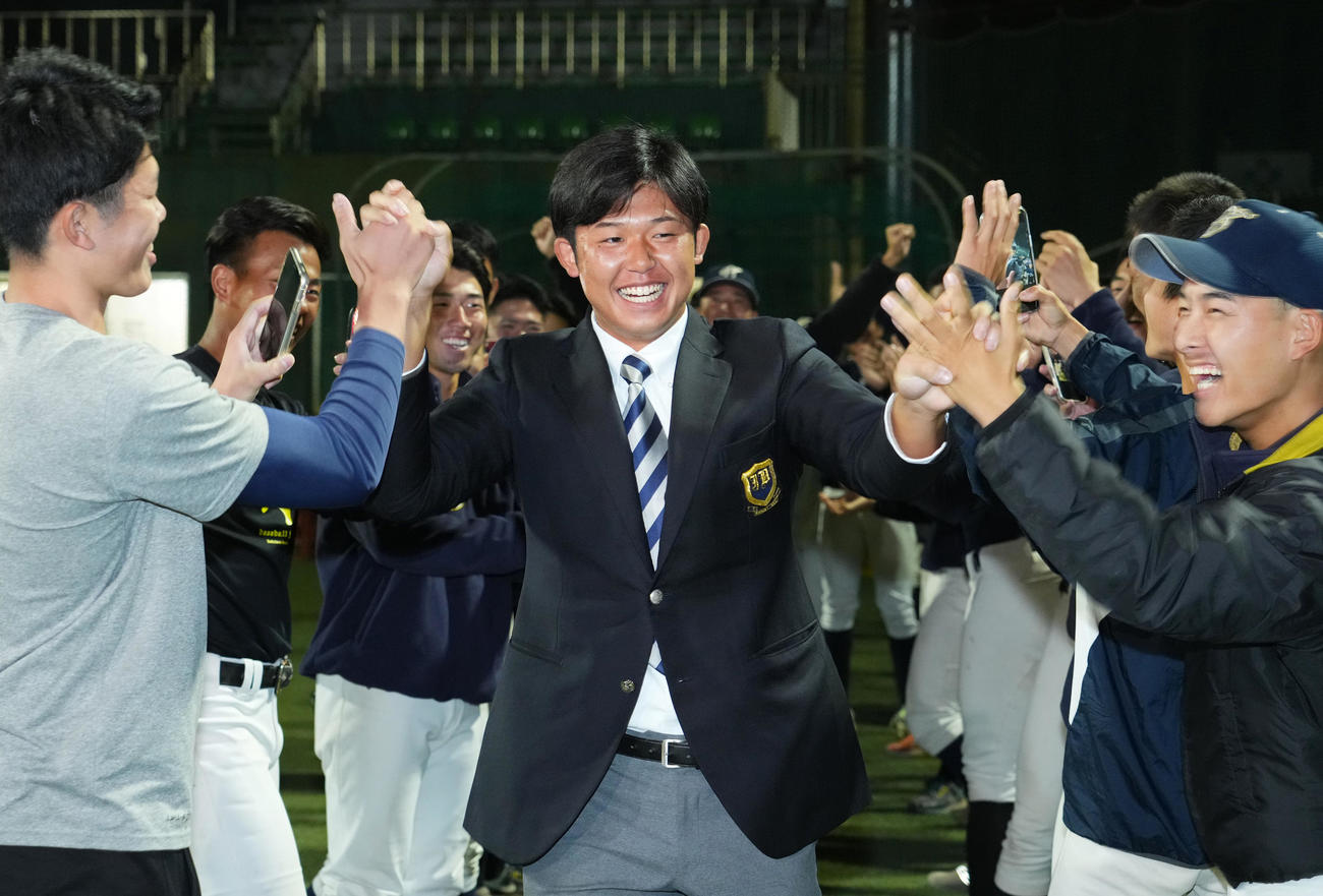 日本ハムから2位で指名を受け、笑顔でタッチをする上武大・進藤（中央）（撮影・菅敏）