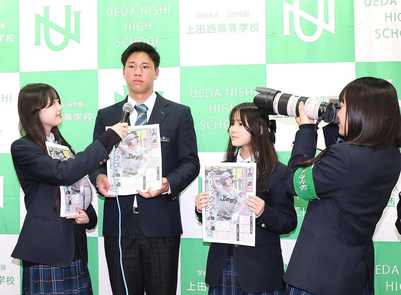 オリックスに1位指名された上田西・横山（中央左）は新聞委員会の号外を手にインタビューを受ける（撮影・足立雅史）