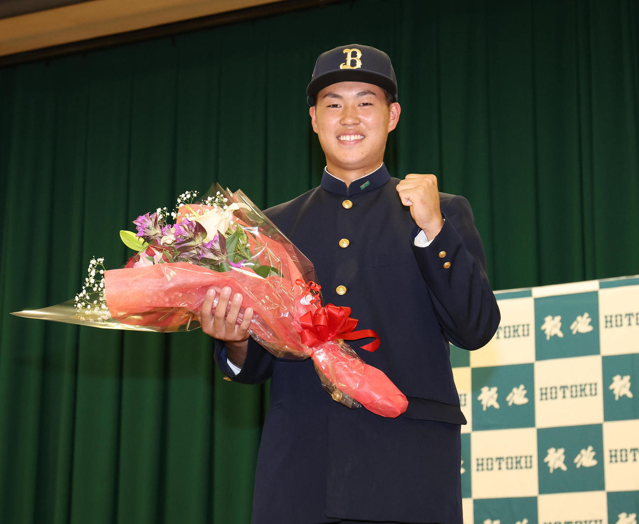 オリックスの帽子をかぶり笑顔でガッツポーズするオリックス4位指名の報徳学園・堀（撮影・白石智彦）