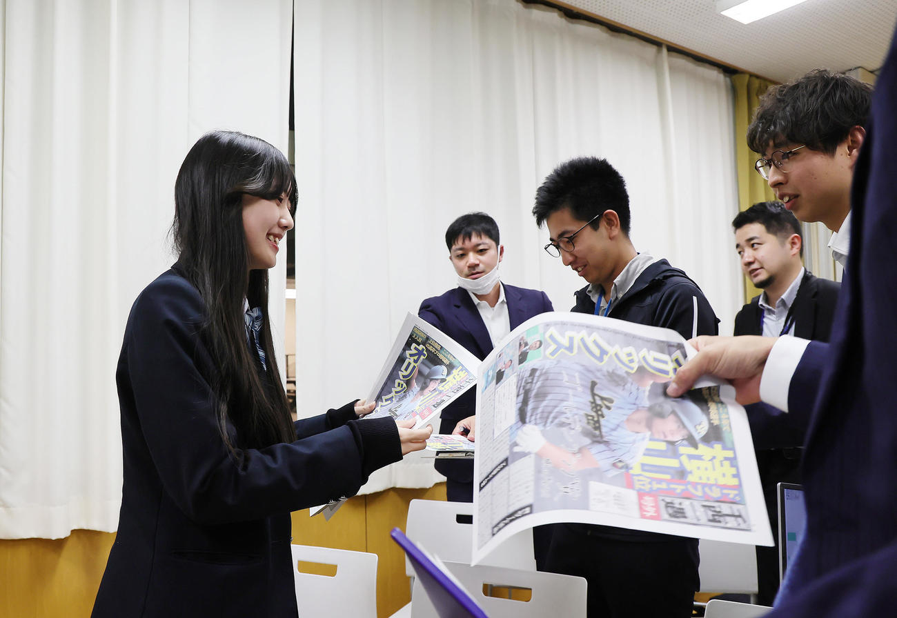 オリックスに1位指名された上田西・横山の号外を配る新聞委員会の生徒（撮影・足立雅史）