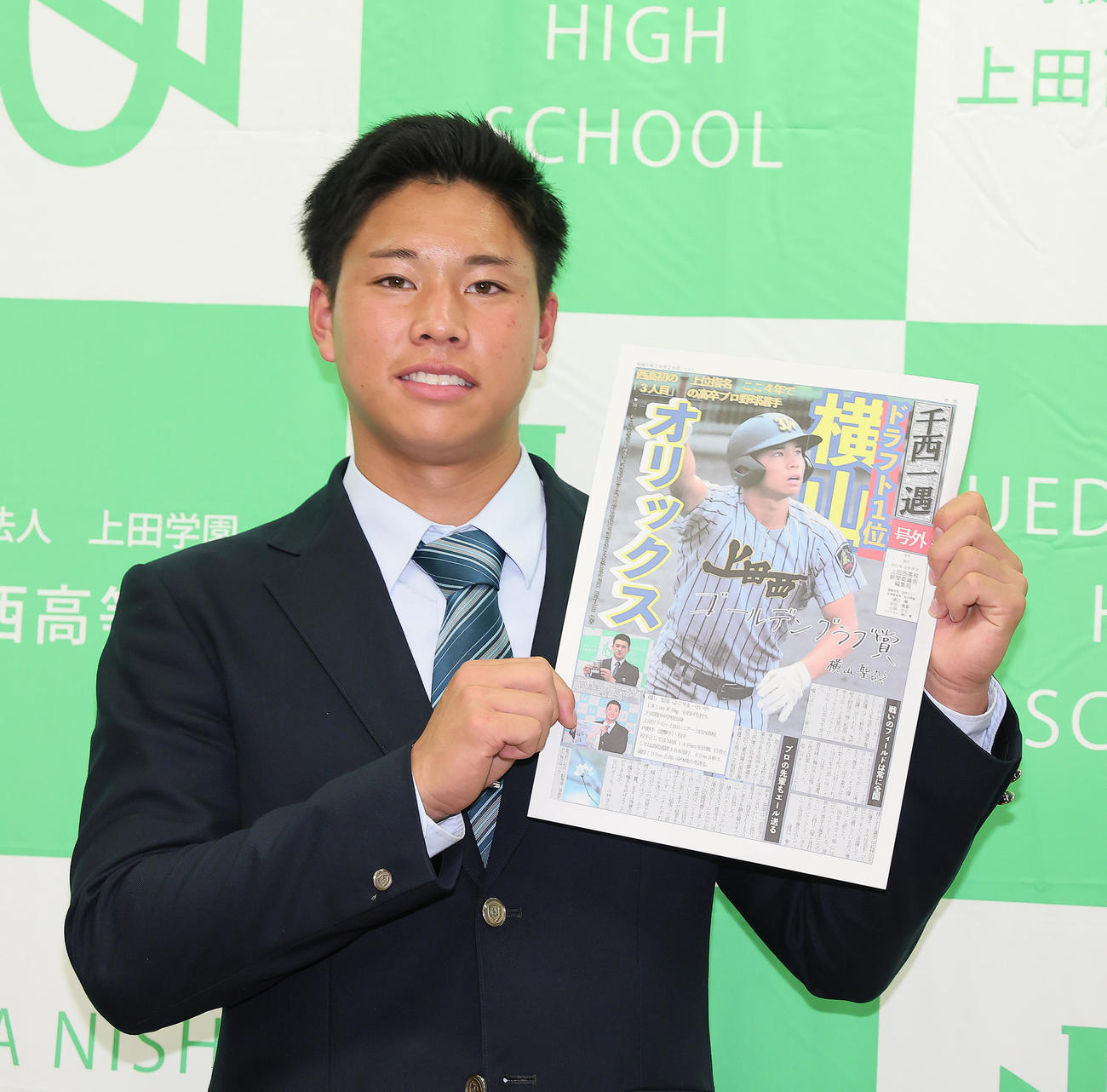 オリックスに1位指名された上田西・横山は新聞委員会の号外を手に笑顔を見せる（撮影・足立雅史）