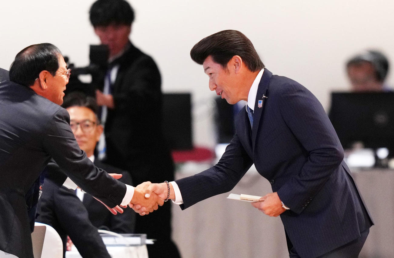 ENEOS度会隆輝の交渉権を獲得し握手を交わすDeNA三浦監督（右）（撮影・横山健太）