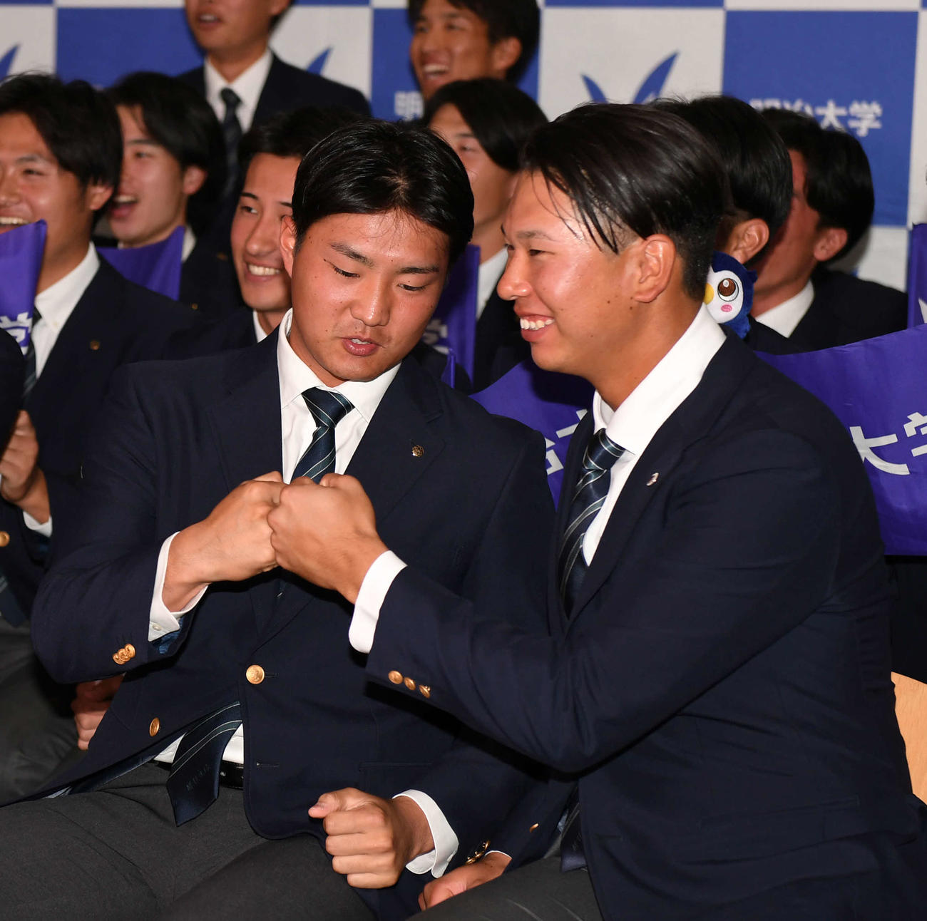 ソフトバンク4位指名の明大・村田賢一は（左）はロッテ1位指名の上田希由翔とグータッチする（撮影・柴田隆二）