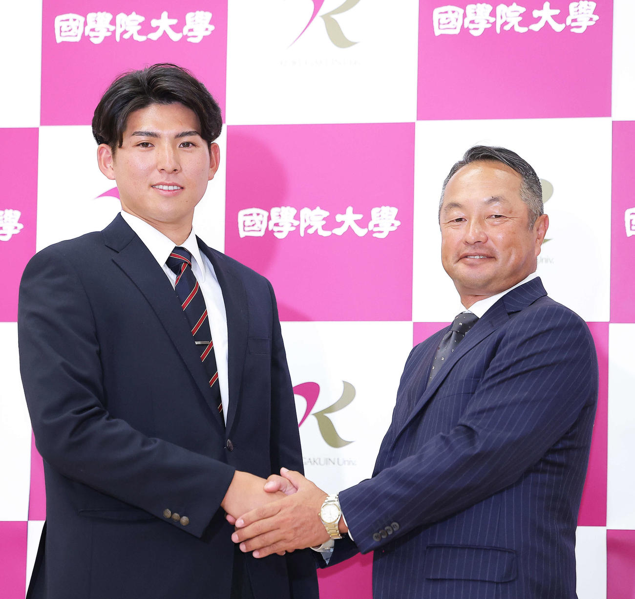 西武1位指名を受け、握手を交わす国学院大・武内（左）と鳥山監督（撮影・河田真司）