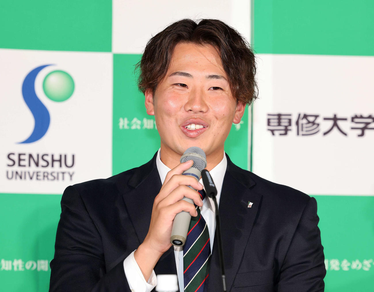 ヤクルト1位指名され笑顔で報道陣の質問に答える専大・西舘（撮影・鈴木正人）