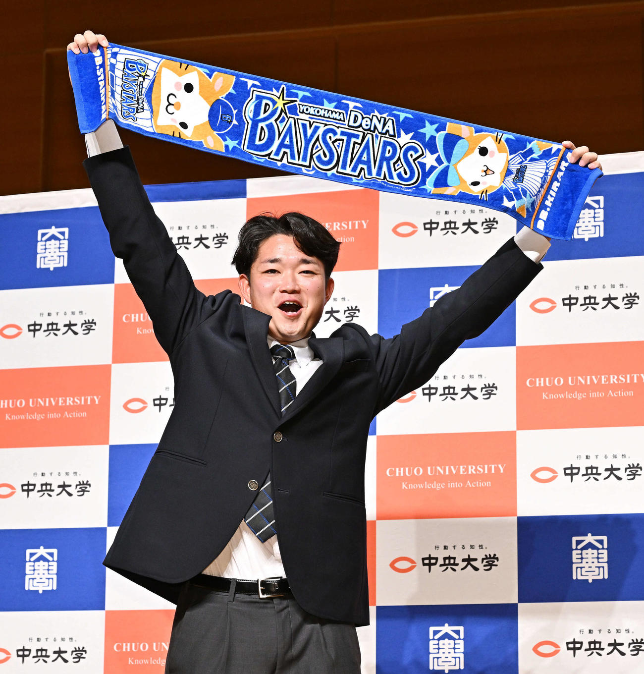 DeNAからドラフト5位で指名された中大・石田はDeNAのタオルを掲げる（撮影・滝沢徹郎）