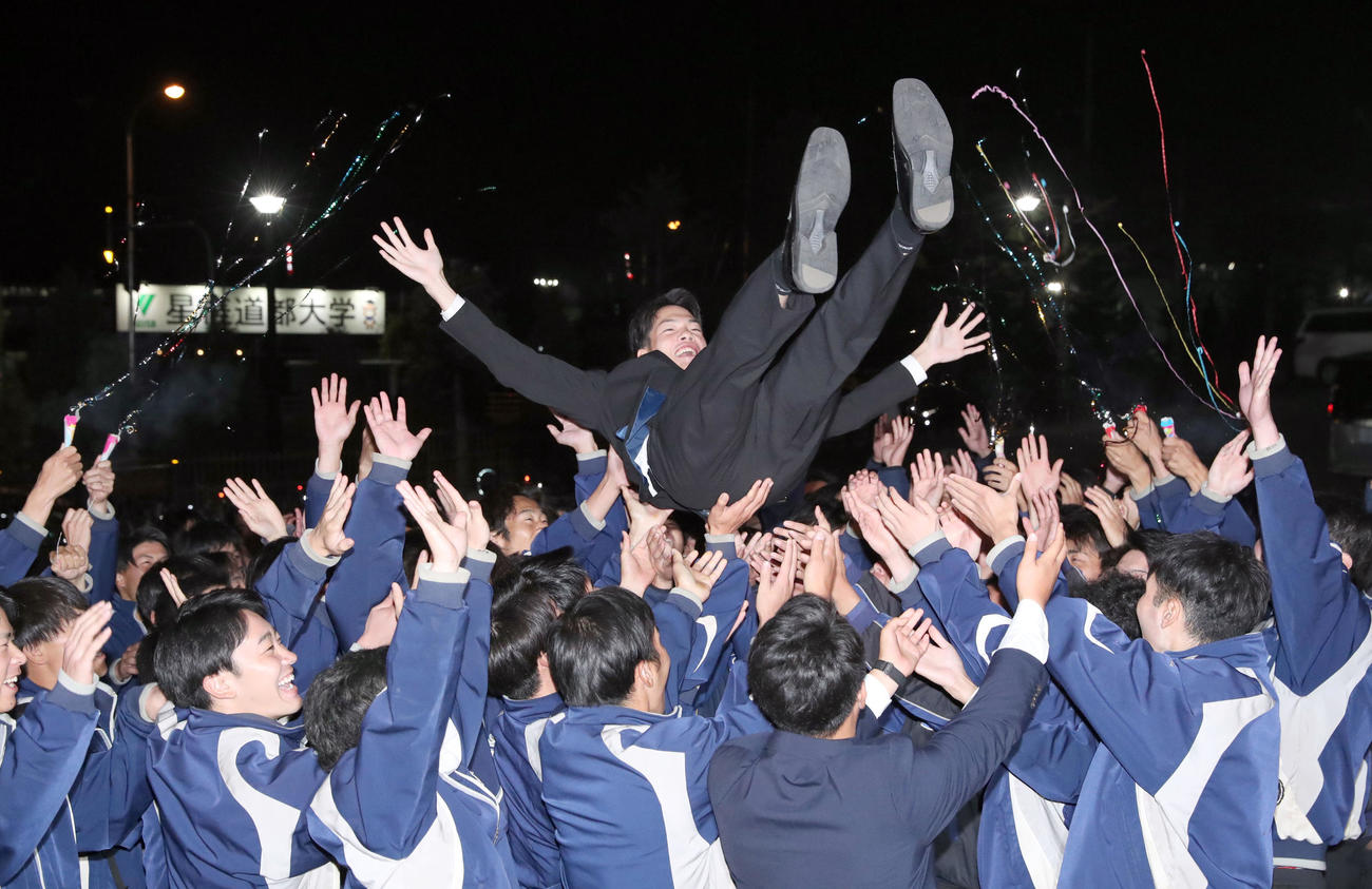 広島からドラフト3位指名を受けた星槎道都大・滝田はチームメートから胴上げされる（撮影・佐藤翔太）