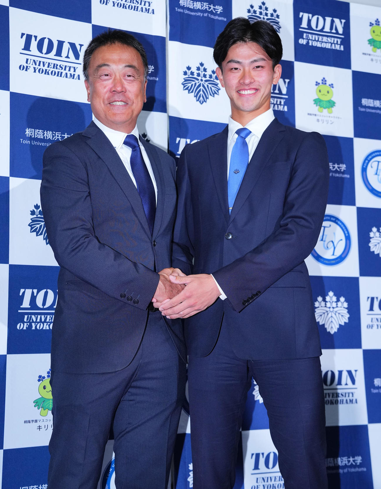 楽天から1位指名を受けた桐蔭横浜大・古謝（右）は斉藤博久監督と笑顔で写真に納まる（撮影・垰建太）