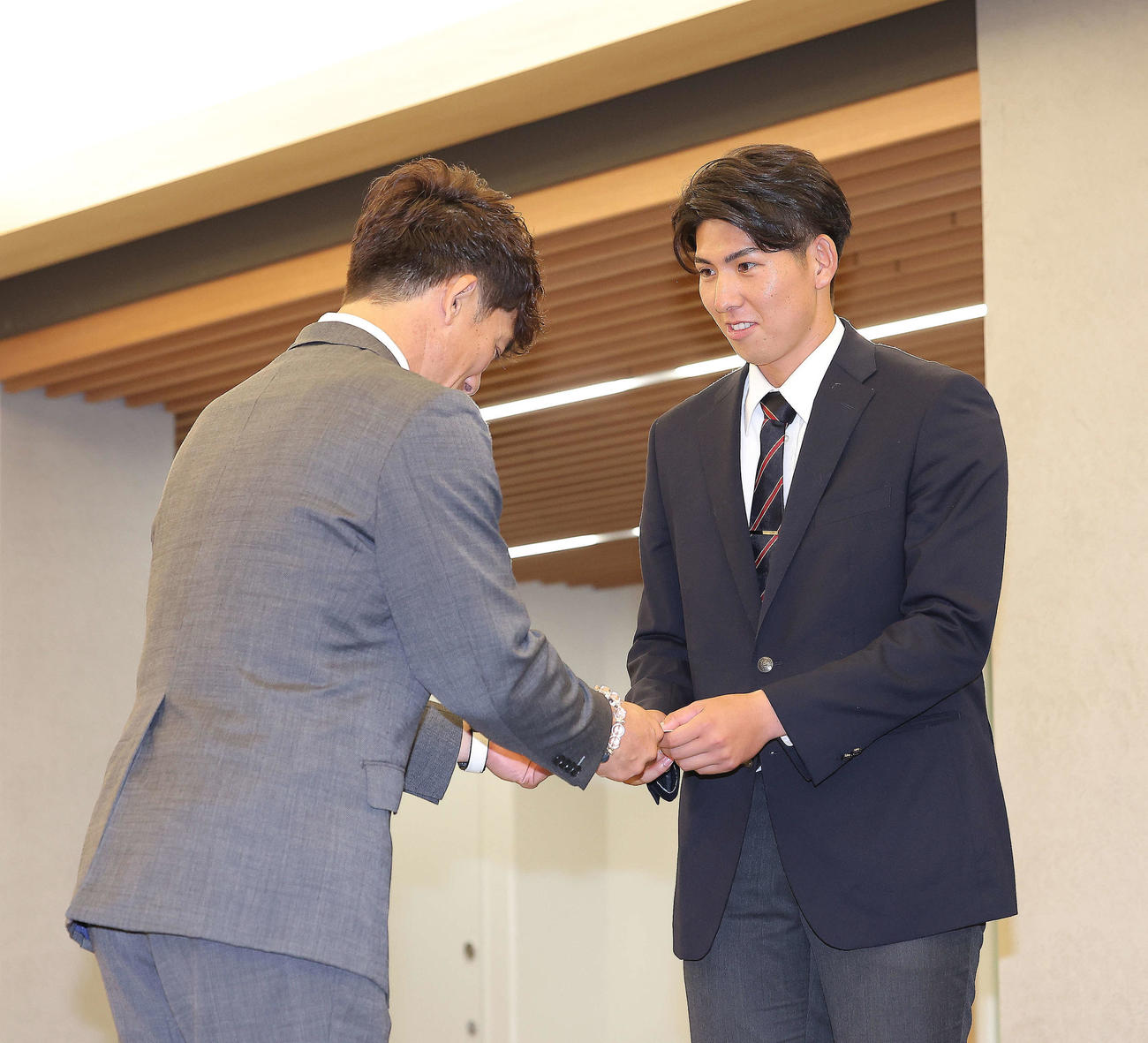 西武松井監督（左）から交渉権確定のくじを受け取る国学院大・武内（撮影・河田真司）