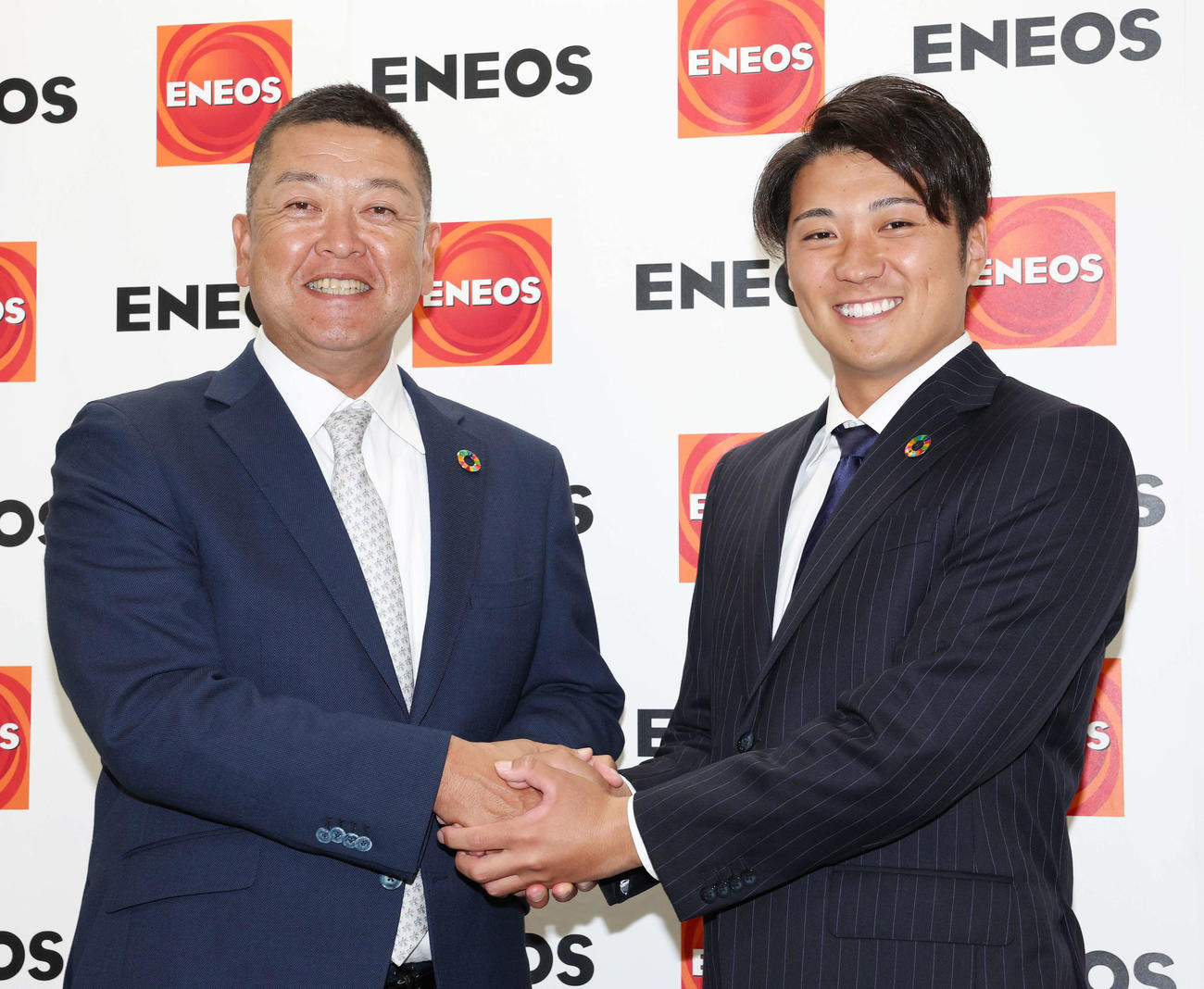 西武から7位指名を受け、ENEOS・大久保監督（左）と笑顔で握手する糸川（撮影・宮地輝）