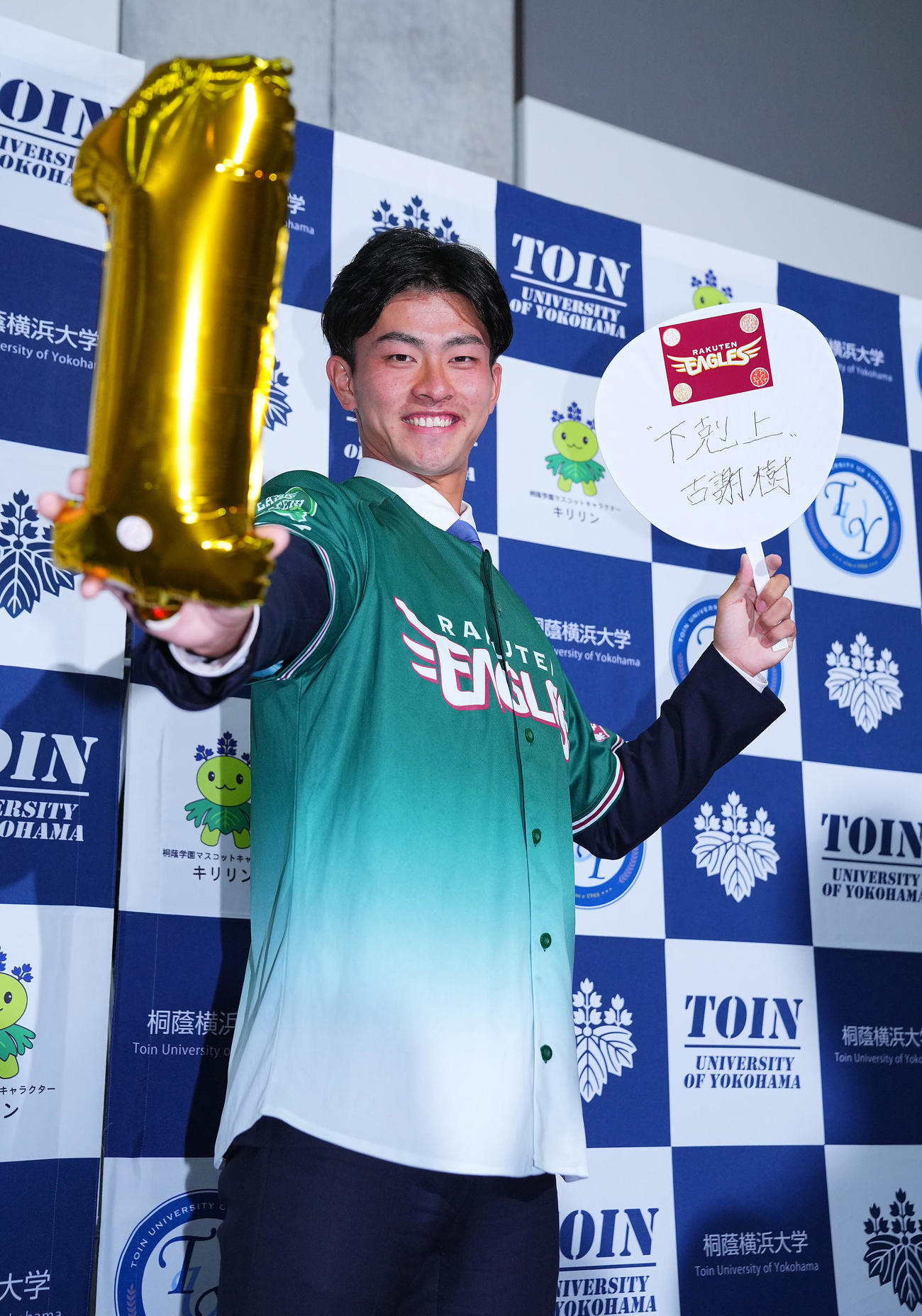 楽天から1位指名を受けた桐蔭横浜大・古謝は「下克上」の言葉を記し笑顔で写真に納まる（撮影・垰建太）