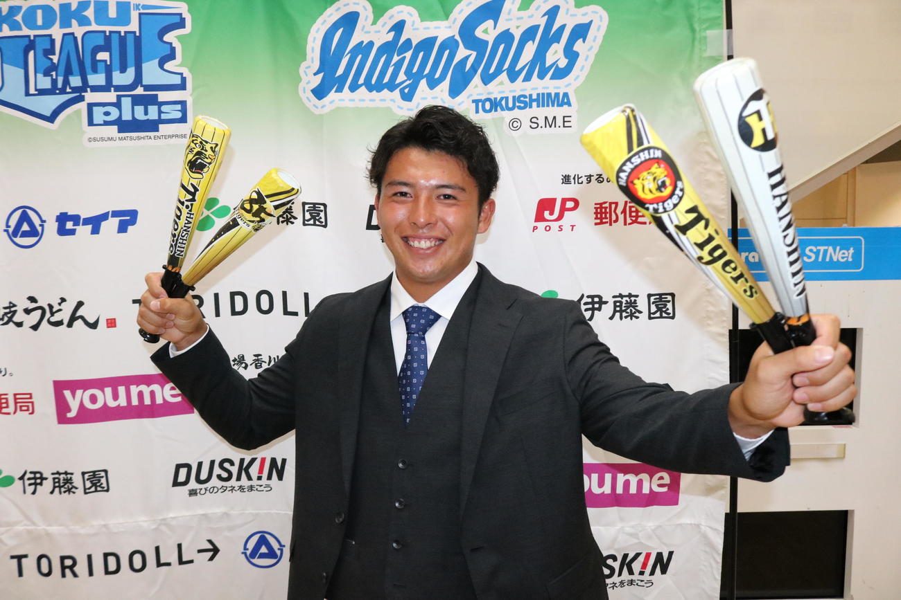 阪神から2位指名を受けた四国IL徳島・椎葉は阪神グッズを手に笑顔を見せる（撮影・林亮佑）