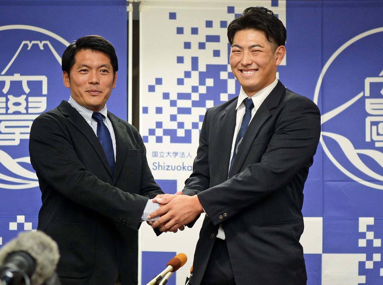 高山監督（左）と握手し、笑顔を見せる静岡大の佐藤内野手