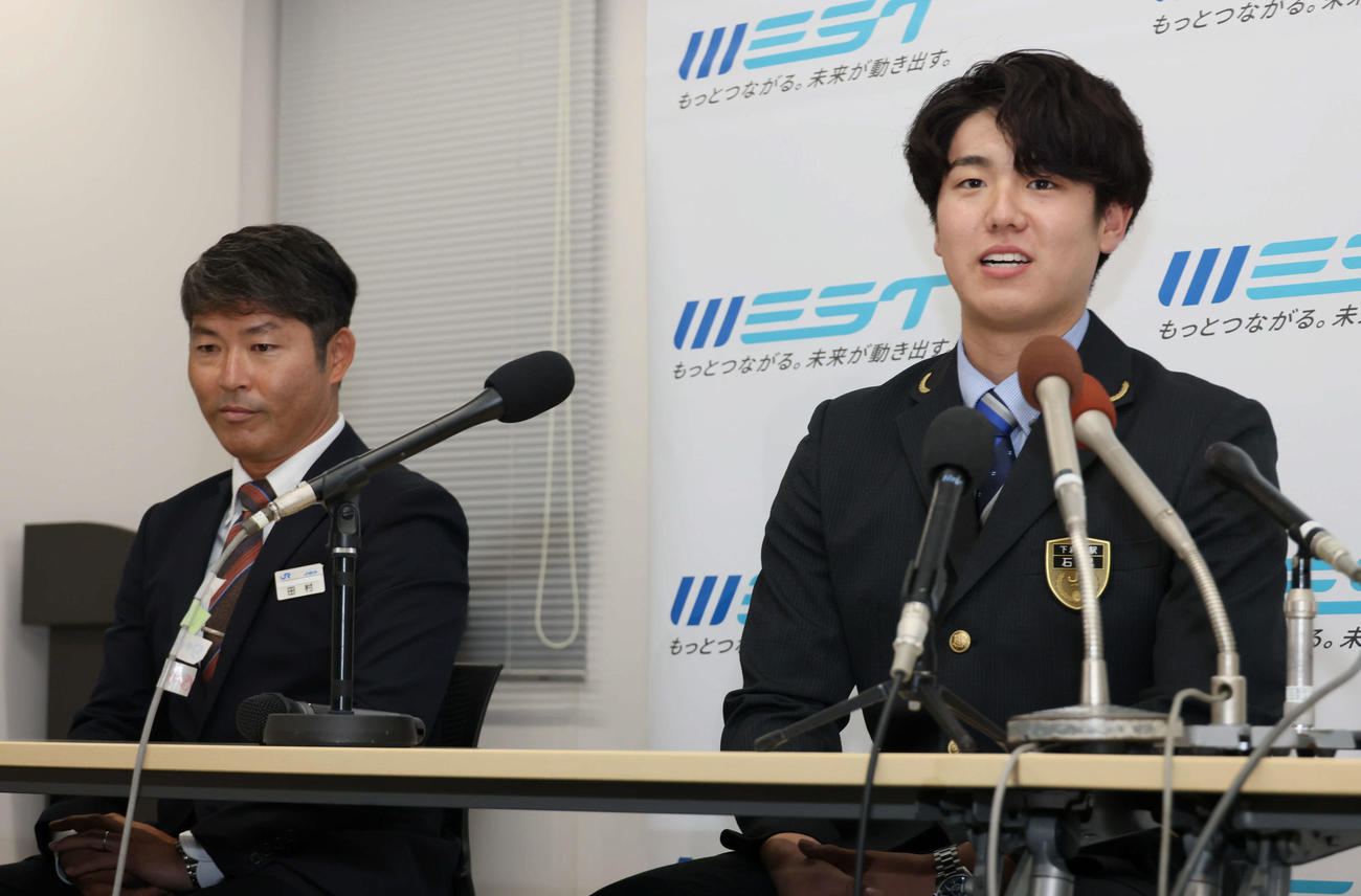 阪神にドラフト5位指名され、笑顔で会見するJR西日本の石黒。左はJR西日本の田村監督（撮影・加藤孝規）
