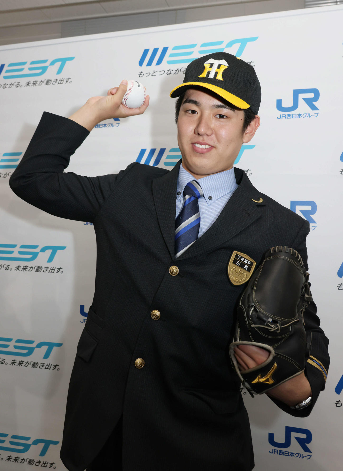 阪神にドラフト5位指名され、ポーズを決めるJR西日本の石黒（撮影・加藤孝規）