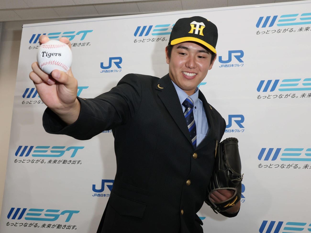 阪神にドラフト5位指名され、ポーズを決めるJR西日本の石黒（撮影・加藤孝規）