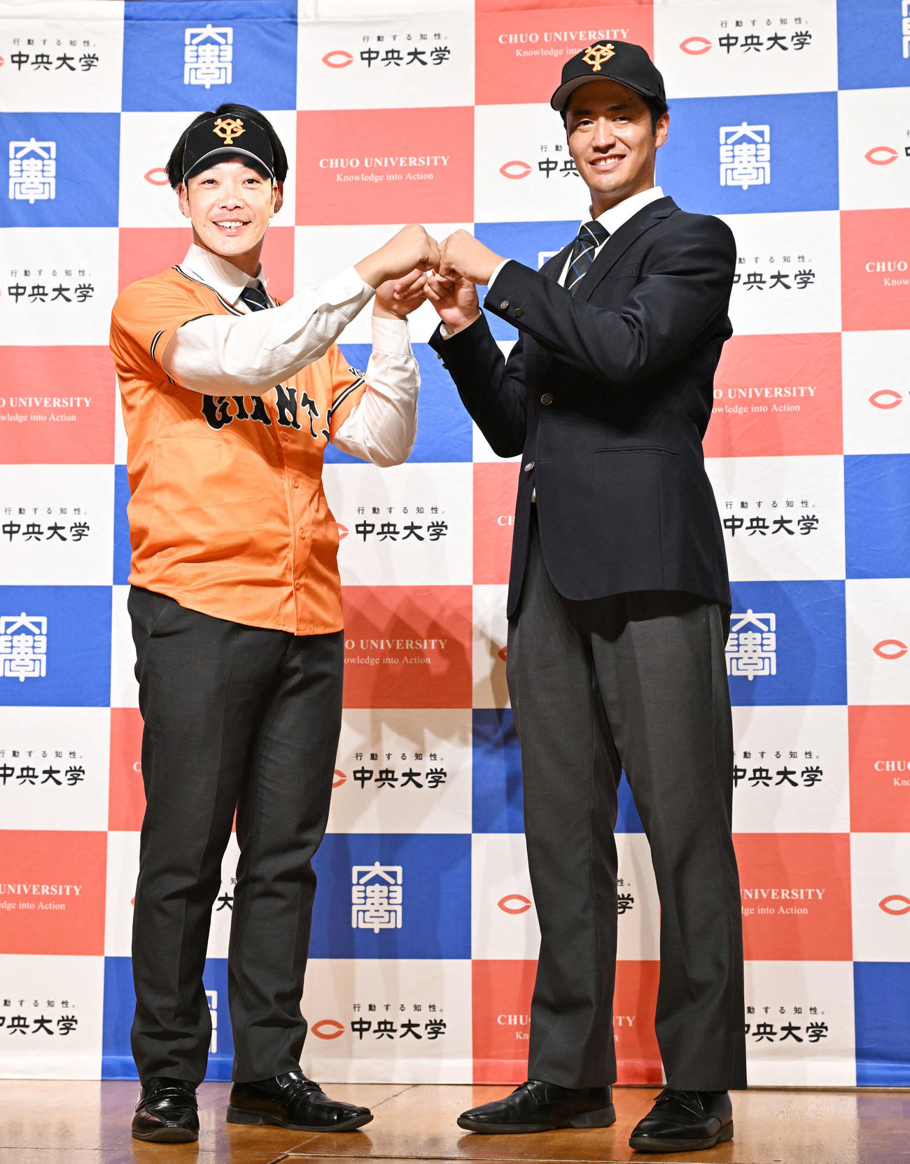 巨人からドラフト1位で指名された中大・西舘（右）は阿部監督に扮（ふん）した学生とグータッチする（撮影・滝沢徹郎）