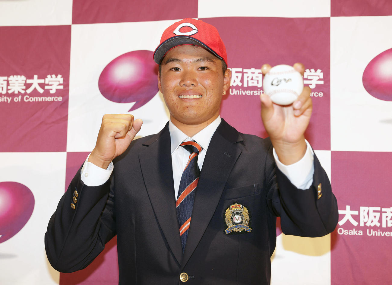 笑顔でポーズを決める広島から2位指名を受けた大商大・高（撮影・前田充）