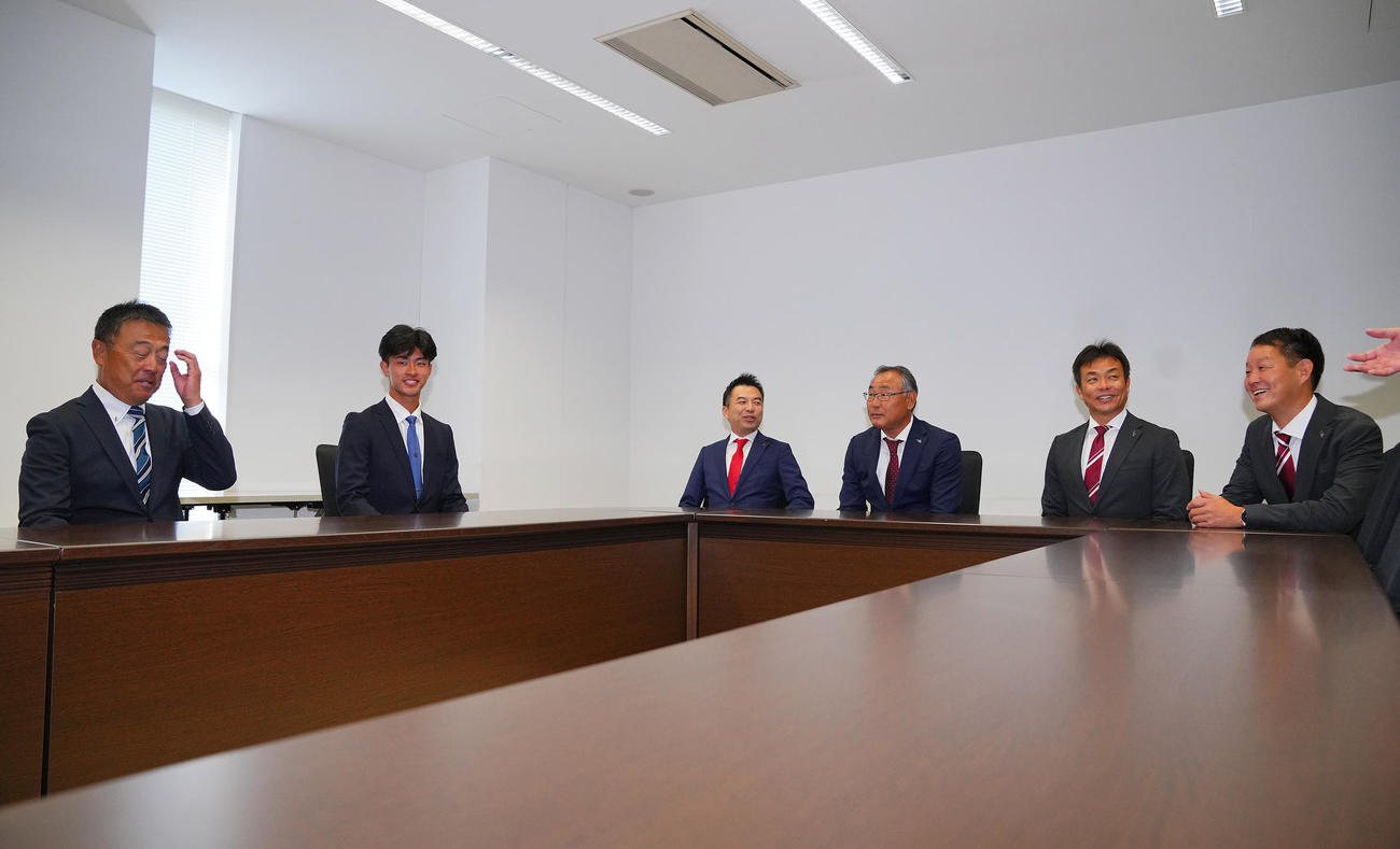 楽天1位の桐蔭横浜大・古謝（左から2人目）は指名あいさつを受け笑顔を見せる（撮影・垰建太）