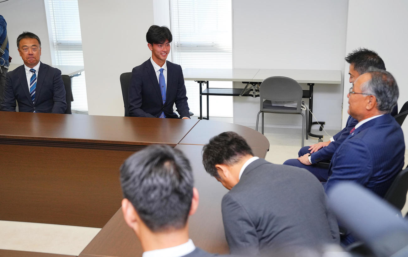 楽天1位の桐蔭横浜大・古謝（左から2人目）は指名あいさつを受け笑顔を見せる。左は斉藤監督（撮影・垰建太）