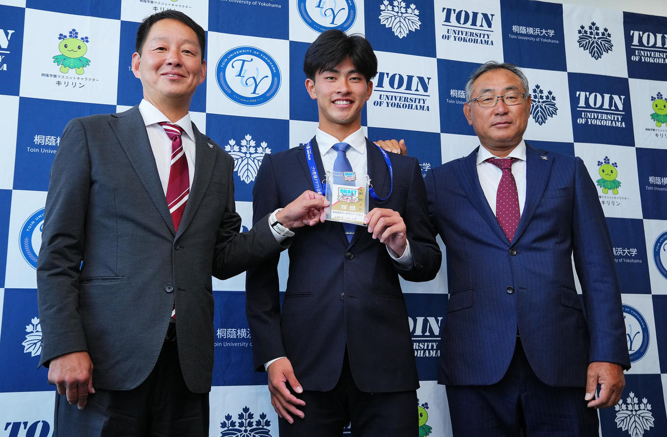 楽天1位の桐蔭横浜大・古謝（中央）は指名あいさつを受け楽天部坂スカウト（左）、後関スカウト部長と笑顔で写真に納まる（撮影・垰建太）
