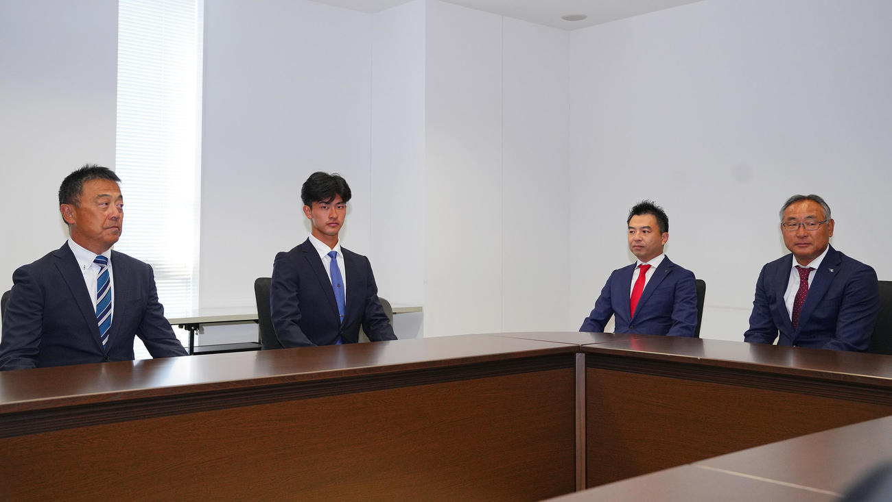 楽天1位の桐蔭横浜大・古謝（左から2人目）は指名あいさつを受ける。左から斉藤監督、1人おいて楽天森井社長、後関スカウト部長（撮影・垰建太）