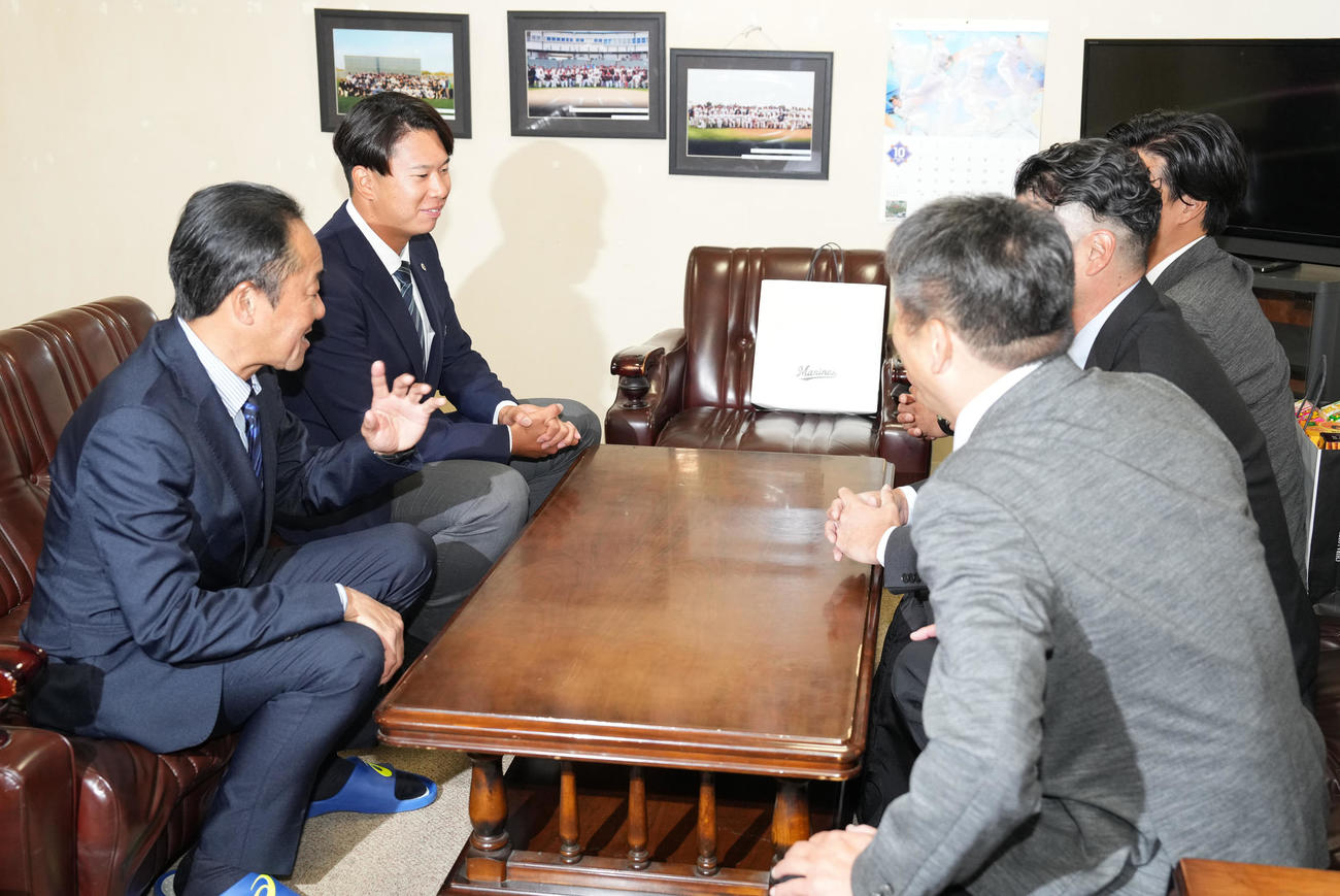 ロッテにドラフト1位指名された明大・上田（左奥）は指名あいさつを受ける（撮影・鈴木みどり）