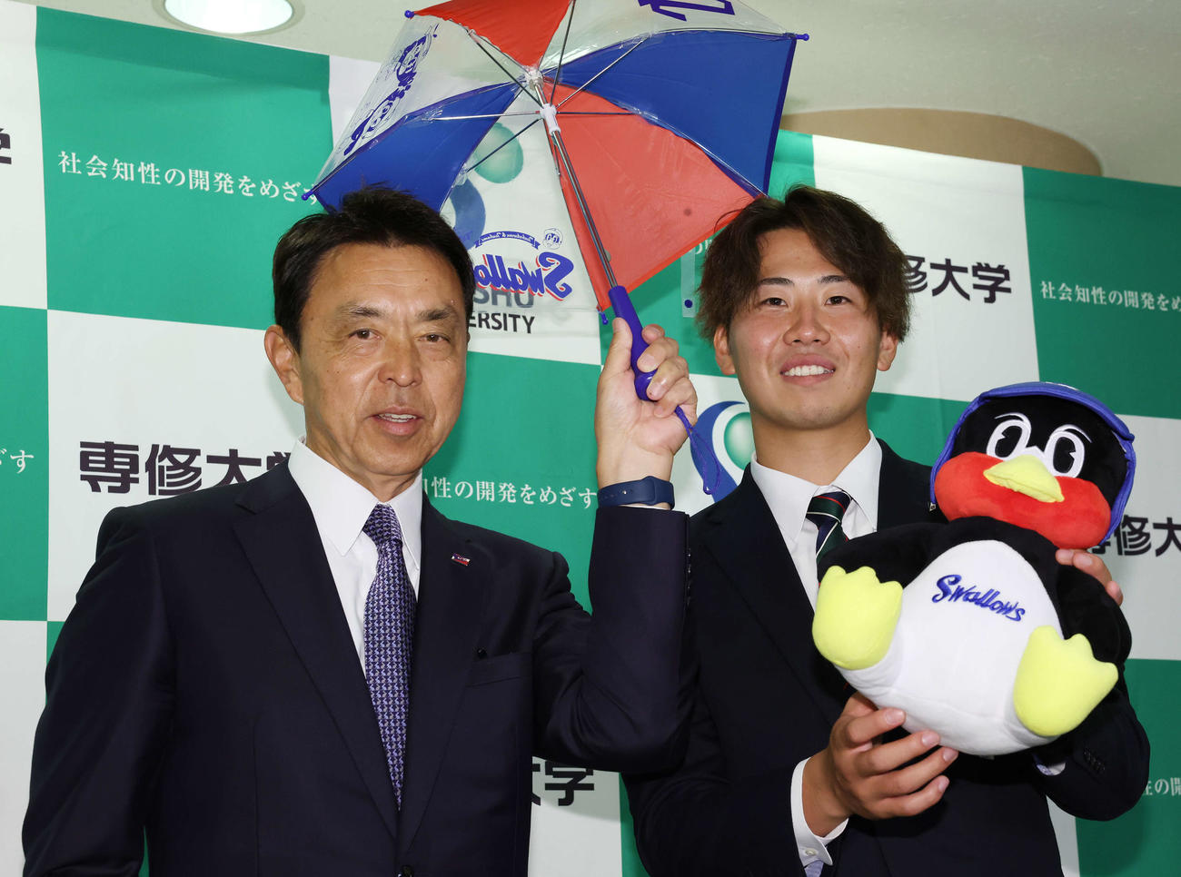 ヤクルト小川GM（左）と笑顔を見せる1位指名の専大・西舘（撮影・宮地輝）