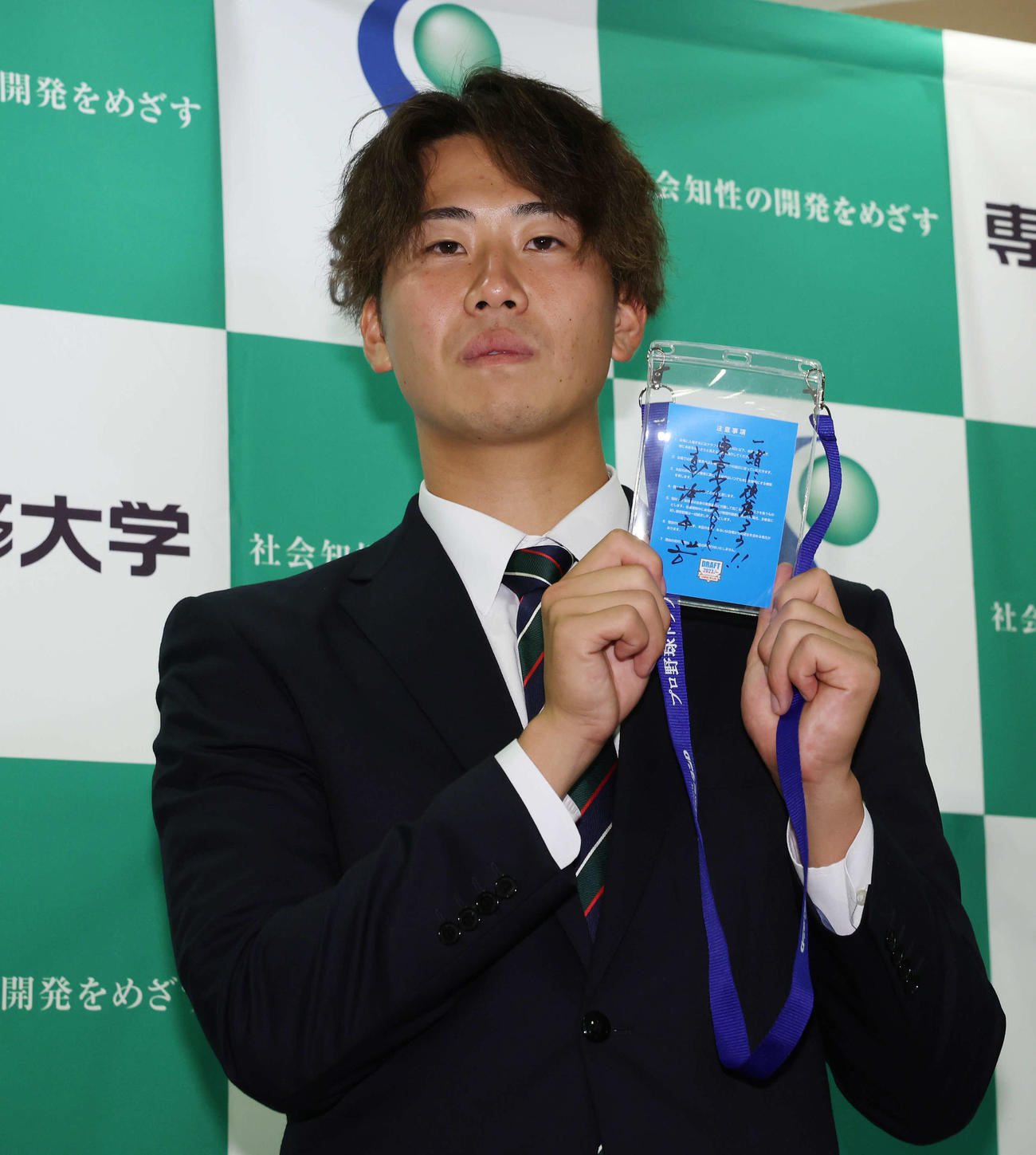 ヤクルト高津監督からのメッセージを手にする1位指名の専大・西舘（撮影・宮地輝）