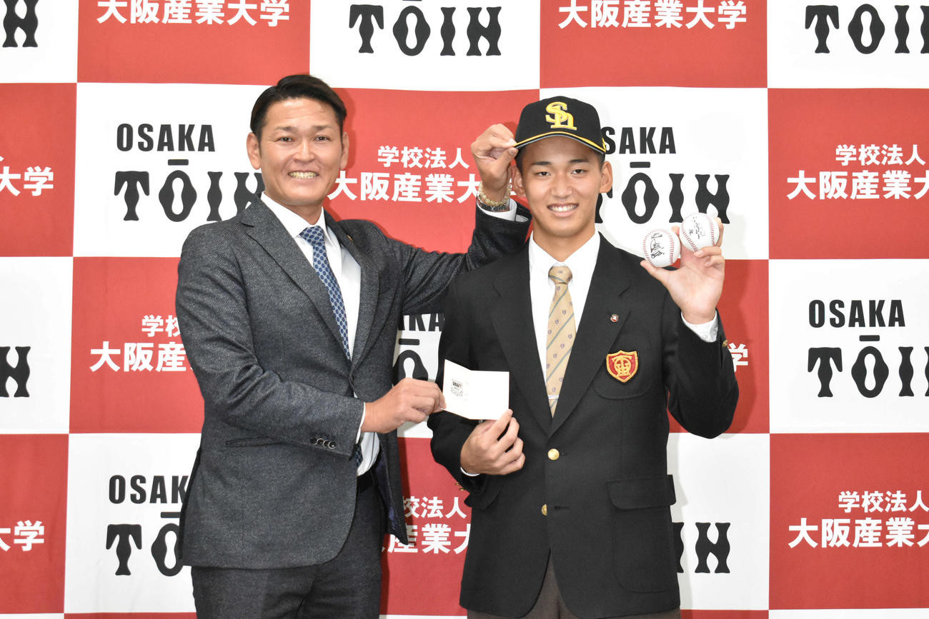 ソフトバンクにドラフト1位指名された大阪桐蔭・前田（右）は永井スカウト部長のあいさつを受け笑顔を見せる（撮影・只松憲）