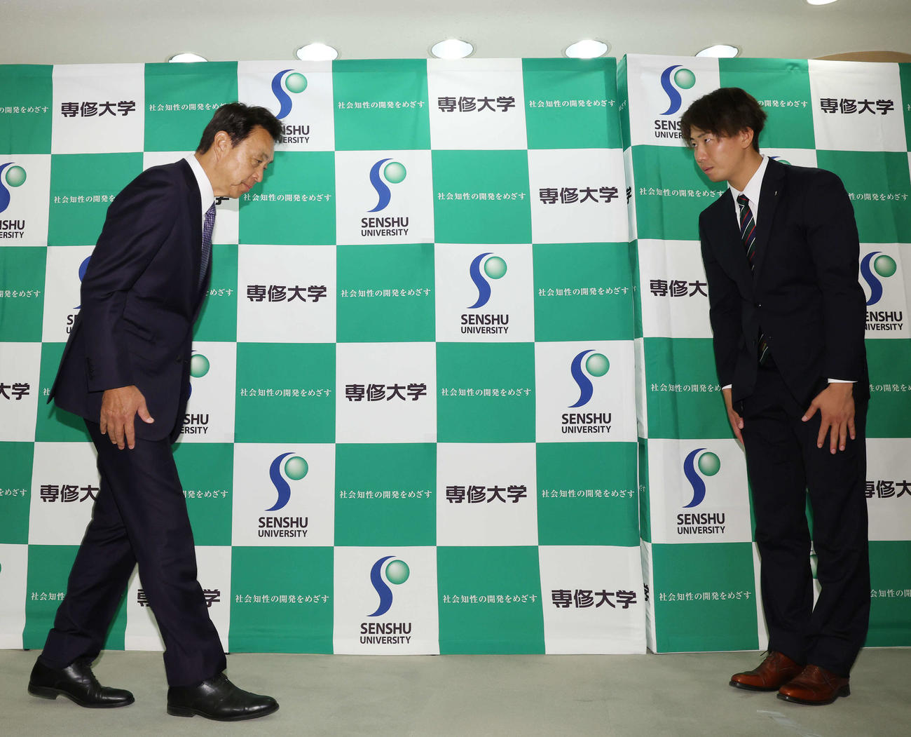 指名あいさつに訪れたヤクルト小川GM（左）を出迎える1位指名の専大・西舘（撮影・宮地輝）