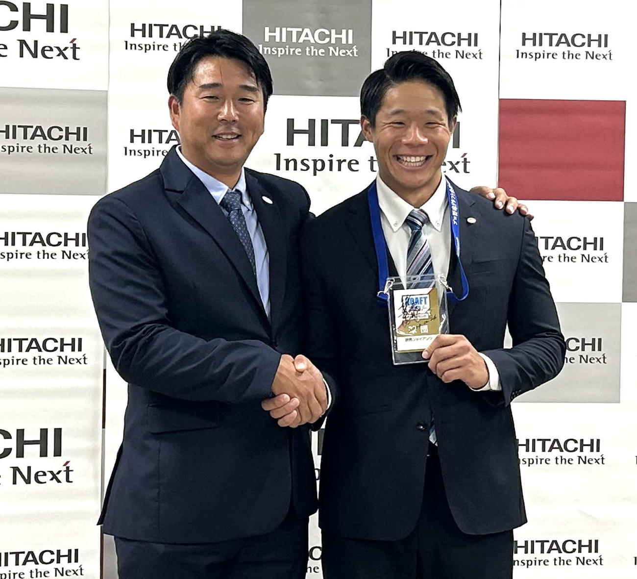 巨人実松スカウト（左）と握手を交わす日立製作所・佐々木（撮影・黒須亮）