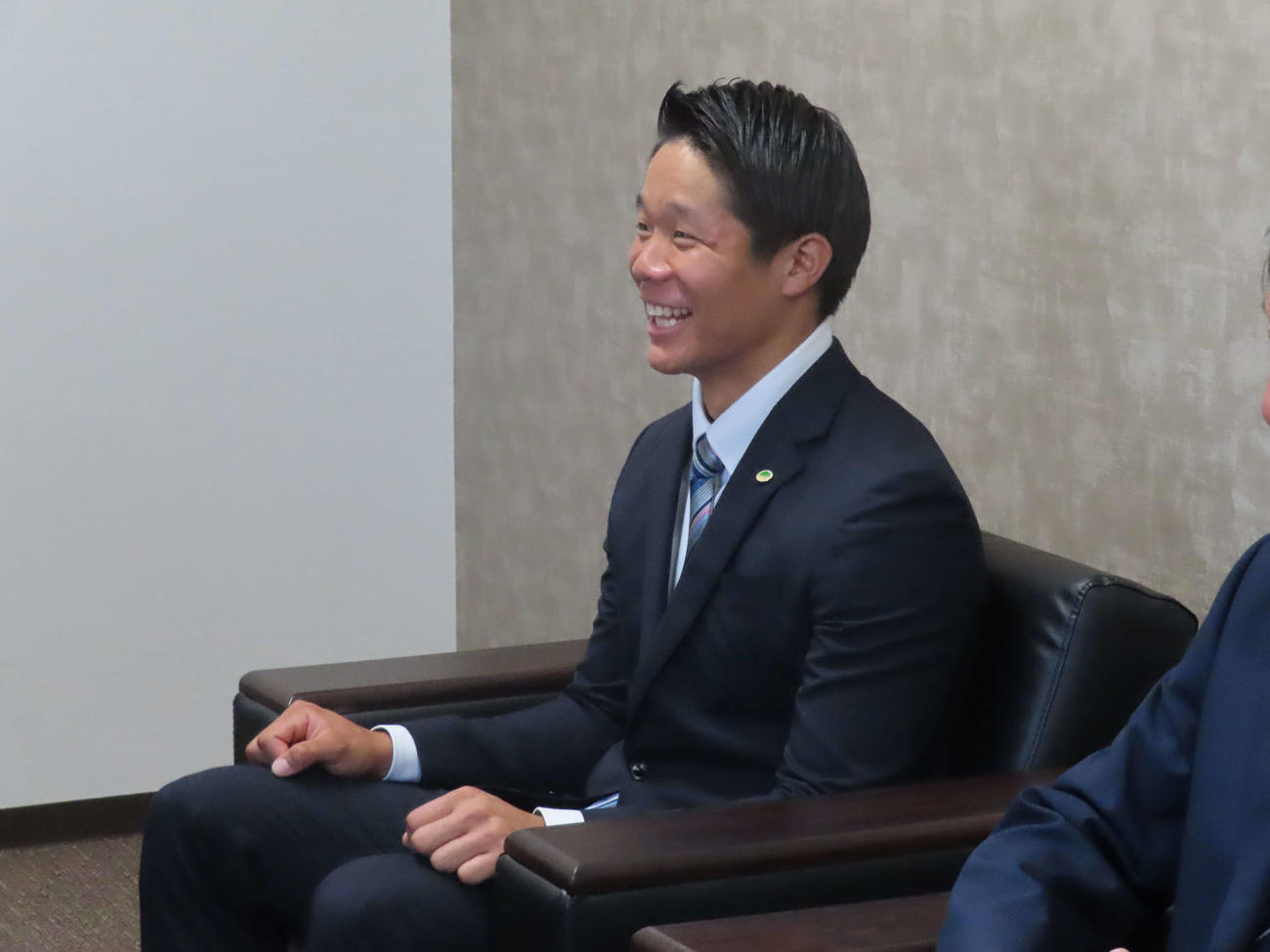 巨人スカウト陣から指名あいさつで笑顔を見せる日立製作所・佐々木俊輔外野手（撮影・黒須亮）