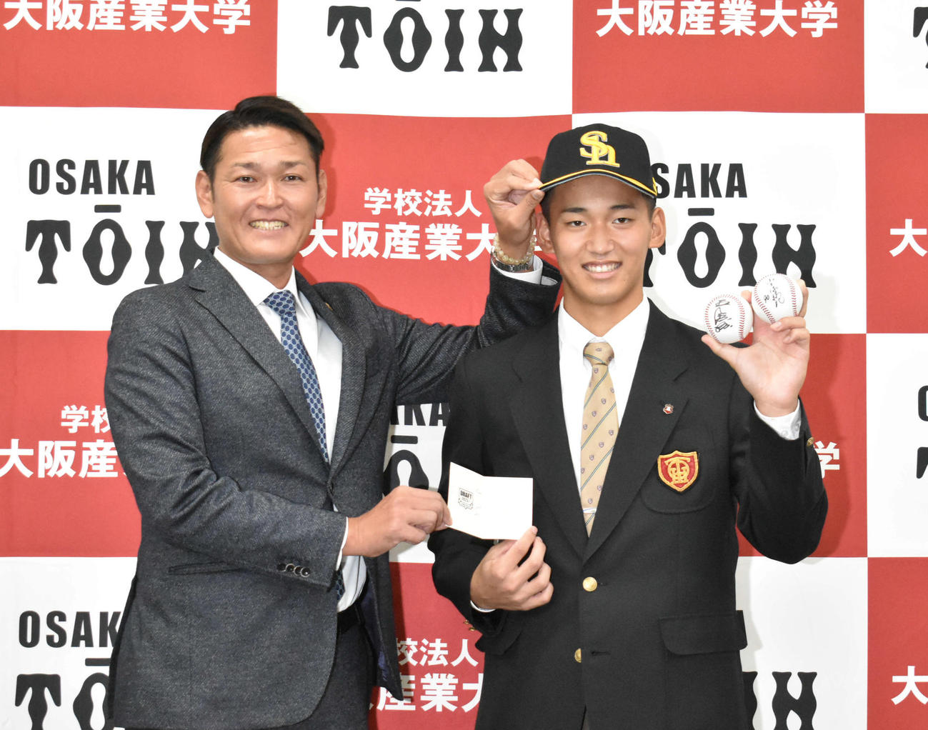 ソフトバンクにドラフト1位指名された大阪桐蔭・前田（右）は永井スカウト部長のあいさつを受け笑顔を見せる（撮影・只松憲）