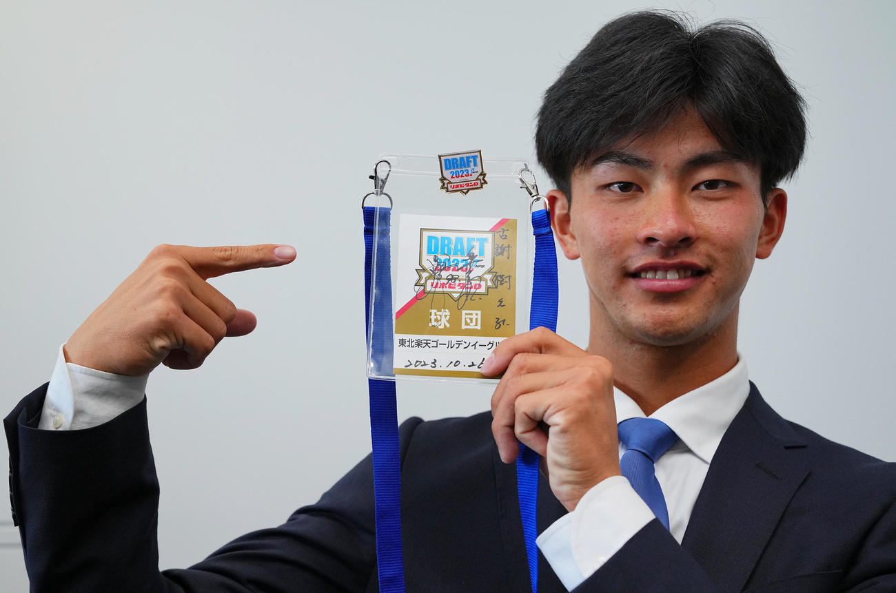 楽天1位の桐蔭横浜大・古謝は楽天今江監督のサイン入りの入場パスを受け取り笑顔を見せる（撮影・垰建太）