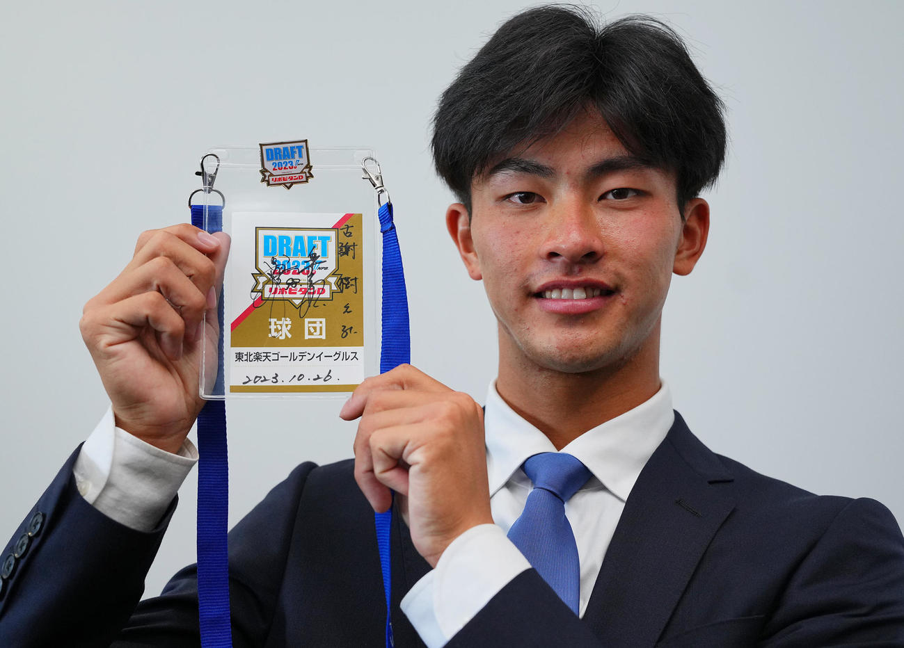 楽天1位の桐蔭横浜大・古謝は楽天今江監督のサイン入りの入場パスを受け取り笑顔を見せる（撮影・垰建太）