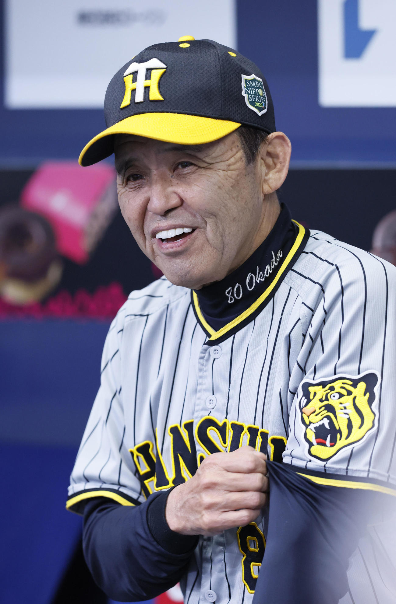 練習中にベンチで笑顔を見せる阪神岡田監督（撮影・藤尾明華）