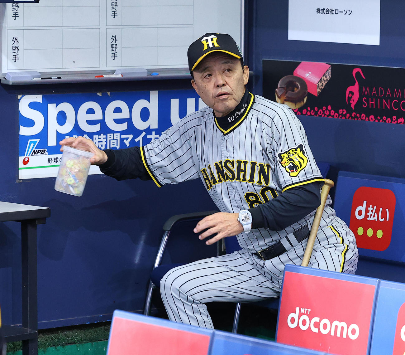 ベンチでパインアメを手にする阪神岡田監督（撮影・藤尾明華）