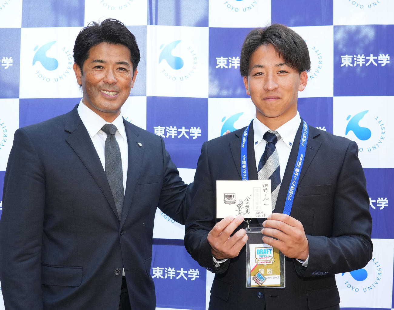 指名あいさつに訪れた稲葉GM（左）から交渉権確定当の当たりくじを受け取り、笑顔を見せる日本ハムドラフト1位の東洋大・細野（撮影・菅敏）