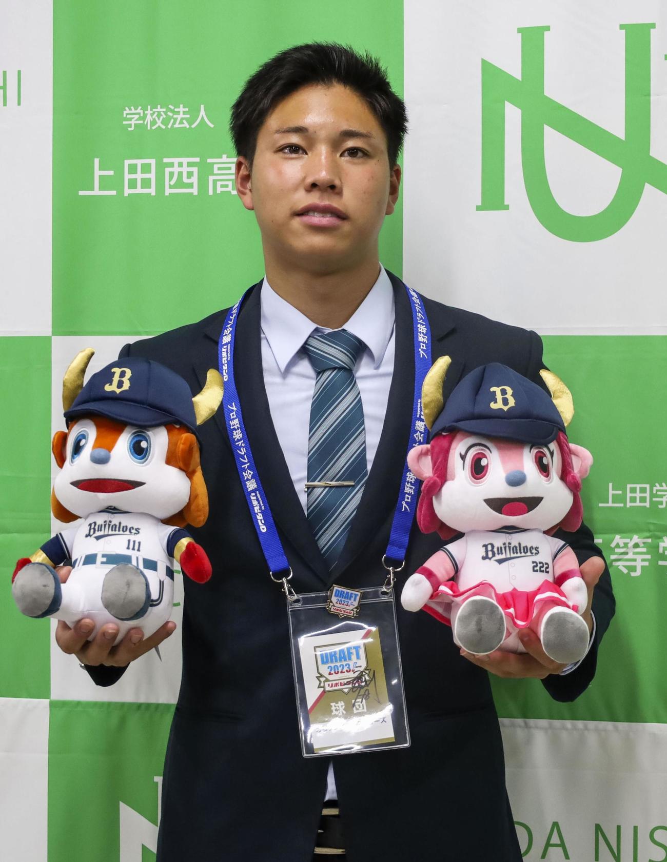 オリックスからドラフト1位指名のあいさつを受け、バファローブル・ベル人形を手に記念写真に納まる上田西・横山（共同）