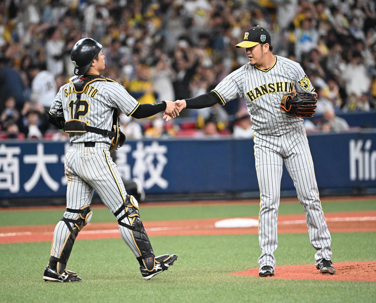 オリックス対阪神　オリックスに勝利しタッチを交わす坂本（左）と岩貞（撮影・和賀正仁）