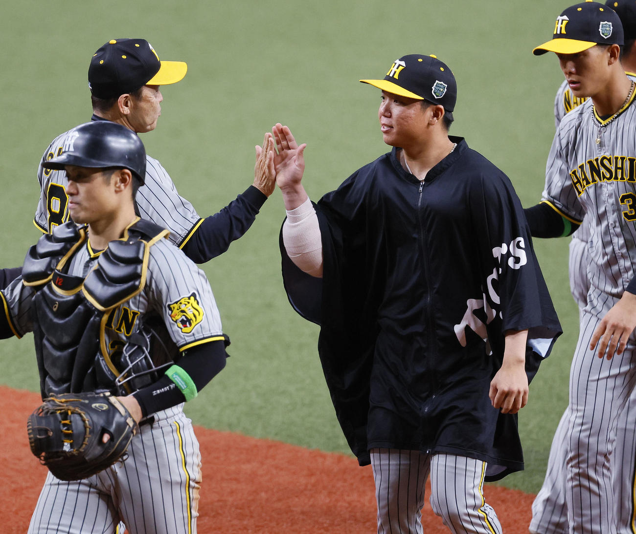 オリックス対阪神　オリックスに勝利し、岡田監督（左）とタッチを交わす阪神村上（中央）（撮影・藤尾明華）