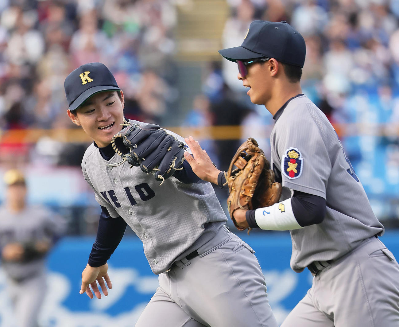 早大対慶大　5回表早大の攻撃を3者凡退に抑えタッチを交わす竹内（左）（撮影・足立雅史）