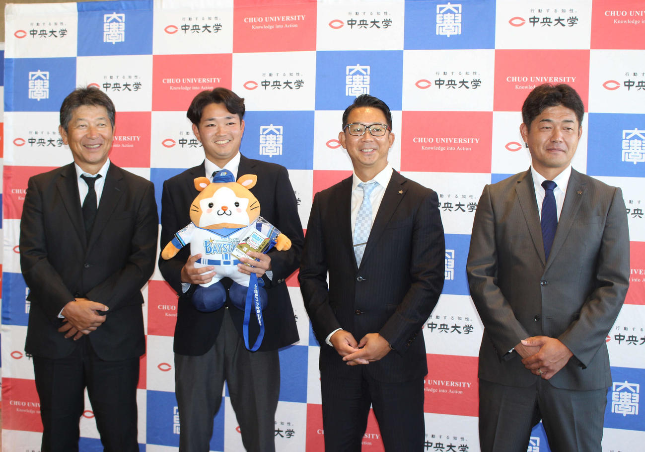 指名あいさつを受け、DB．スターマンを手に笑顔のDeNAドラフト5位の中大・石田（左から2人目）（撮影・久保賢吾）