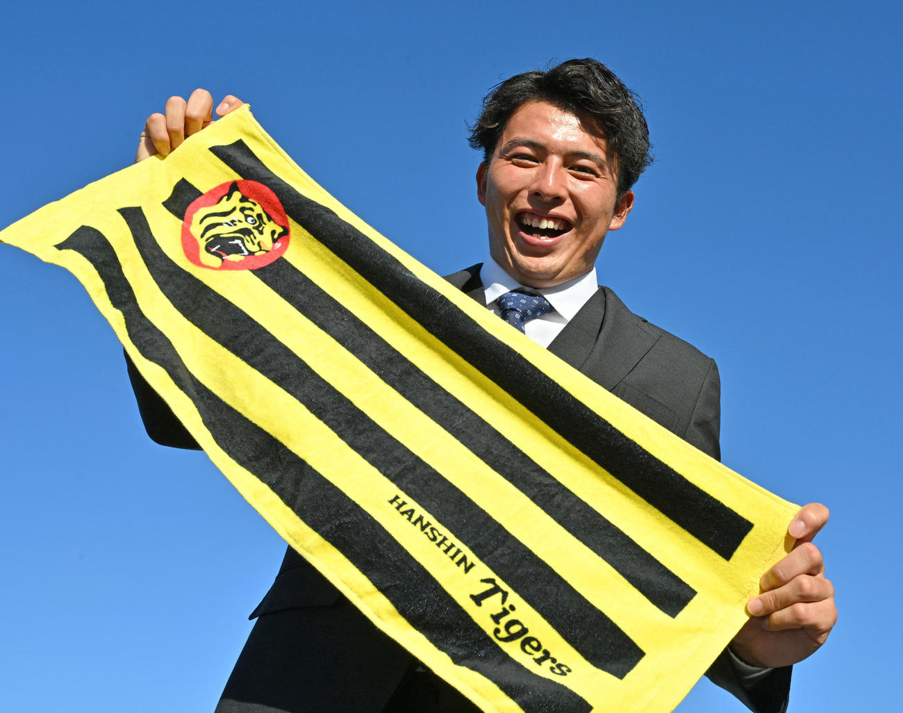 青空を背に笑顔を見せる阪神ドラフト2位の徳島インディゴソックス椎葉（撮影・石井愛子）