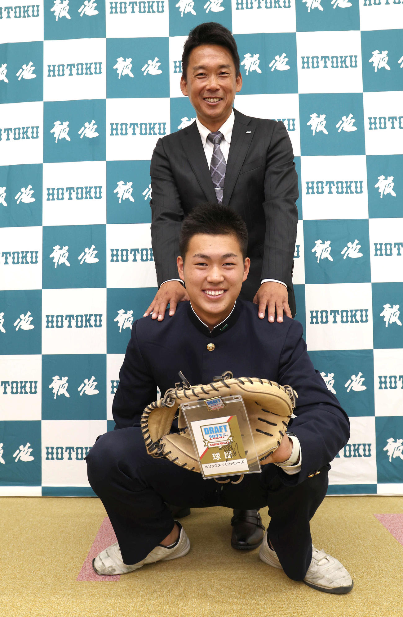 オリックス下山スカウト（後方）とキャッチングポーズで記念写真に納まるドラフト4位の報徳学園・堀（撮影・白石智彦）