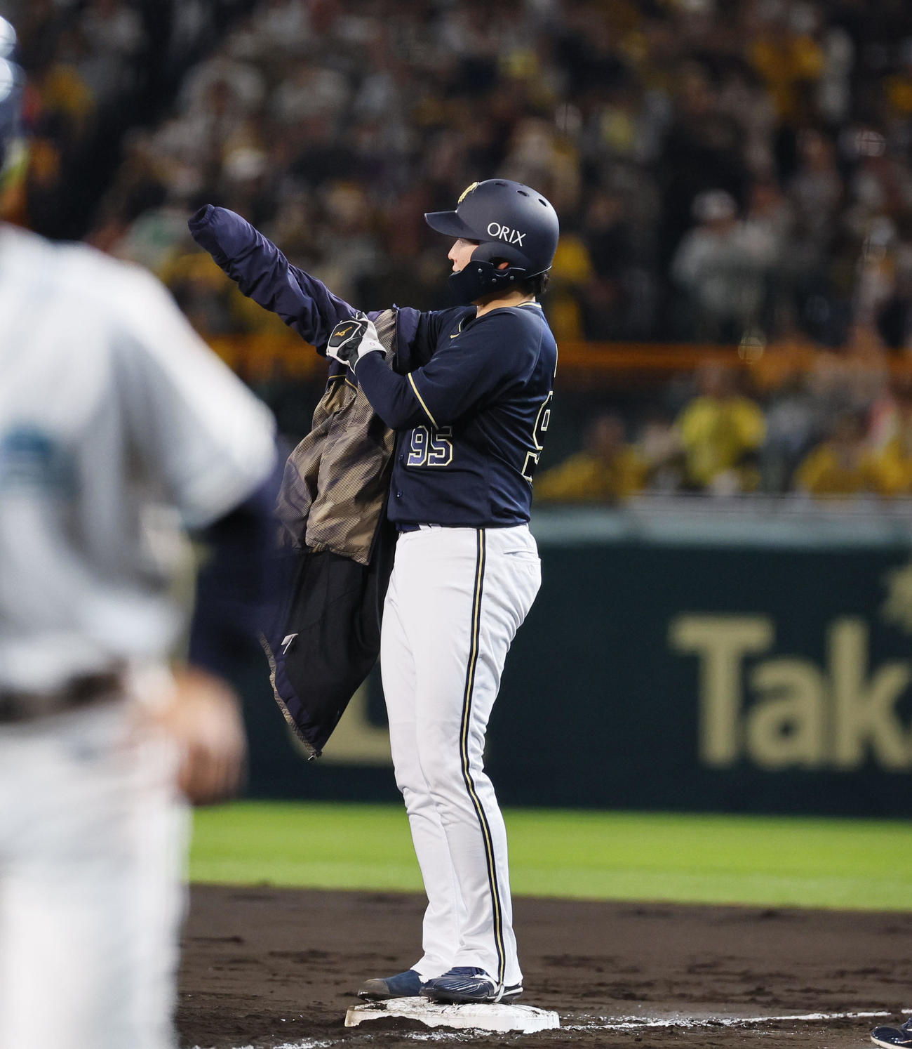 阪神対オリックス　5回表オリックス1死一、二塁、一塁ベース上で上着に袖を通す東（撮影・藤尾明華）