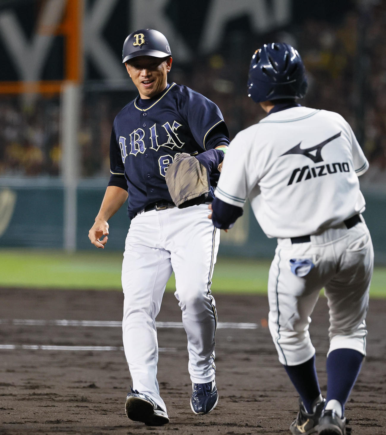 阪神対オリックス　5回表オリックス1死一、二塁、一塁走者東が着用できなかったウインドブレーカーをボールボーイに渡す田口コーチ（撮影・藤尾明華）